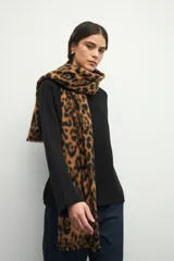 Bufanda rectangular de tejido suave color marrón con estampado animal print de leopardo en negro.