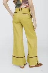 Pantalón acampanado color mostaza con ribetes marrones en los laterales y en el ruedo.