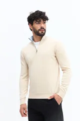 Sweater de tejido liso color verde oscuro, con cuello medio y cierre frontal parcial plateado. Presenta puños y cintura acanalados, y un pequeño logo bordado en el pecho.