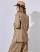 Blazer blanco de lino con cuello con solapa, bolsillos sastre y mangas fruncidas.