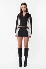 Campera deportiva negra con recortes grises en mangas y laterales. Cierre frontal y calce slim fit. Estampa de logo a tono en el recorte delantero.