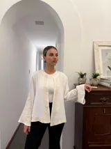 Campera blanca de algodón con bordados florales en color crema, corte recto y mangas acampanadas.