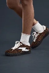 Championes de mujer con estampado de leopardo, cordones blancos y detalle lateral en forma de rayo blanco. Suela gruesa de goma negra.