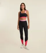 Calza deportiva negra con detalles en rosa en la cintura, laterales y tobillos.