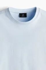 Remera celeste de punto de algodón pesado, corte holgado, cuello redondo ribeteado, hombros caídos y bajo recto.