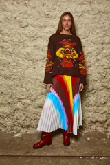 Sweater tejido de lana color marrón con bordado artesanal de flores en el frente y mangas. De calce holgado, cuello redondo y puños acanalados.