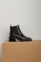 Botas Chelsea de cuero color marrón con elástico lateral negro, puntera metálica cuadrada y suela track.