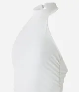 Blusa blanca sin mangas con cuello alto halter, botón en la parte de atrás del cuello, fruncidos laterales y efecto brilloso.