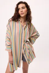 Vestido camisero a rayas verticales de colores pastel, con cuello camisero, cierre frontal con botones y mangas largas.