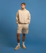Bermuda masculina color beige confeccionada en tela french terry, con cintura elástica, cordón interior para ajustes y bolsillos cargo.