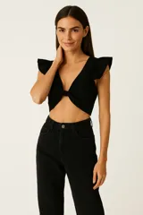 Top negro de viscosa con escote en V, anudado en el centro y mangas cortas con volados.