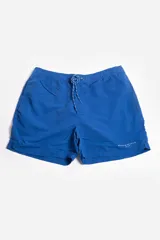 Short de baño liso color azul con cintura elástica ajustable con cordón, bolsillos laterales, tela ligera de secado rápido, suspensor interno y logo estampado.