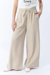 Pantalón beige de corte palazzo con cintura elastizada y cordón ajustable.