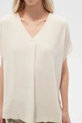 Blusa color beige de lino, holgada y con cuello en V.