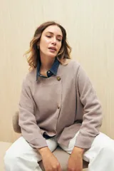Sweater tejido color verde oliva con cruce irregular y botones a contraste.