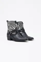 Bota de cuero negra con diseño de animal print en la parte superior y tachas decorativas.