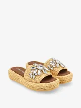 Sandalia tipo plataforma color negro con base de acabado trenzado y capellada ancha decorada con apliques de diseño floral.