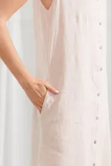 Vestido túnica midi sin mangas, color blanco, con cuello camisero y cierre frontal con botones.