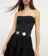 Cinturón de metal plateado con argollas y rodelas.