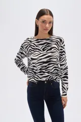 Sweater de tejido de punto, color crema, con estampado floral en tonos rosados y marrones. Presenta cuello redondo y mangas largas.