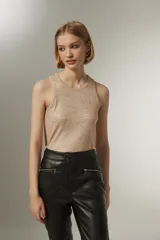 Musculosa de punto color beige con brillos dorados.