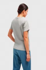 Remera negra con estampado de una mujer sentada en un sillón con un trago en la mano.