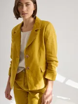 Blazer color mostaza de lino con corte estructurado, solapas con pespuntes y bolsillos con solapa.