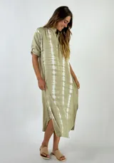 Vestido de corte fluido color nude, con botones frontales y mangas cortas.