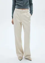 Pantalón de jean color beige, de corte recto, tiro medio y largo hasta el tobillo.