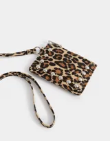 Monedero de cuerina con estampado animal print, correa lateral y aplique de tachas decorativas. Cuenta con cierre superior y correa lateral.