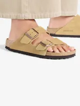Sandalias Birkenstock Arizona color arena, con dos correas ajustables con hebillas metálicas.