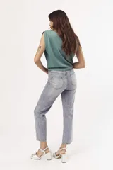 Pantalón de jean celeste de corte mom, con tachas plateadas.