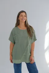 Blusa verde militar de lino, corte holgado, mangas cortas, cuello redondo y bolsillo en el pecho.