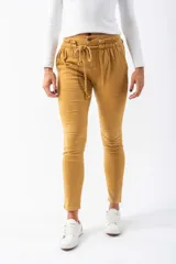 Pantalón elastizado color mostaza, con detalles plisados en los bolsillos y cinturón de cordón.