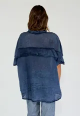 Camisa color amarillo con cuello clásico, cierre frontal con botones y mangas cortas con volados.