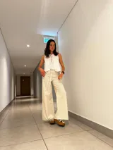 Pantalón de vestir color crema con rayas verticales, corte palazzo y cintura alta con cordón ajustable.