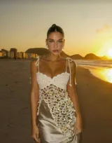 Top de punto color crudo con lentejuelas multicolores, tirantes finos y corte irregular.