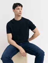 Remera de tejido de punto color azul marino, de manga corta y cuello redondo.