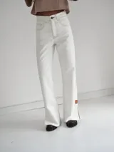 Pantalón vaquero celeste de tiro alto, corte recto con tajo lateral y terminación en cuero.
