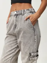 Pantalón jean gris de corte recto, con bolsillos laterales y tobillos ajustados con elástico.
