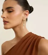 Aretes colgantes medianos con base metálica dorada con detalles en forma de hoja y un colgante de cristal liso.