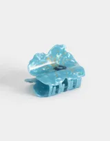 Broche para el pelo con forma de flor celeste con detalles dorados y centro azul marino.