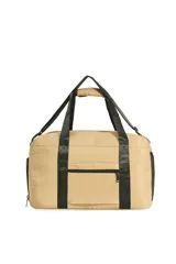 Bolso tipo duffel o de viaje color beige, con asas de mano y correa ajustable para hombro en color negro. Presenta múltiples bolsillos exteriores, incluyendo uno con tapa y hebilla de ajuste, y otro con cierre de cremallera.