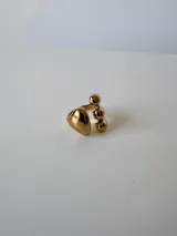 Anillo plateado de acero quirúrgico hipoalergénico con diseño abierto y tres gotas en un extremo y una gota en el otro.