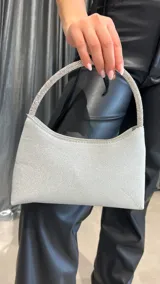Cartera plateada con manija rígida cubierta de strass.