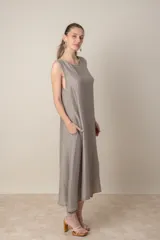 Vestido midi marrón de tejido tramado, corte suelto, sin mangas y con bolsillos laterales.