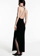 Vestido negro de punto fino, largo, con escote de pico, espalda abierta y tirantes finos.