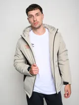 Campera corta de abrigo Umbro Crafted Pro, color negro con paneles laterales en gris. Presenta capucha con cordón ajustable, cierre frontal completo y logo de la marca bordado en el pecho.