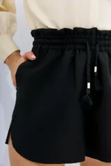 Short de calce relajado color azul, con cintura elastizada y cordón de ajuste, tajos laterales y bolsillos laterales.