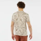 Remera beige con estampado de hojas de palmera en tonos marrones.
